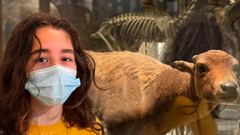 A Latina high schooler next to an animal.