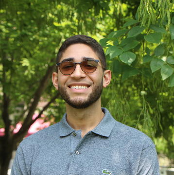 Scientist, Carlos Rivera-Lopez standing in front of a tree.
