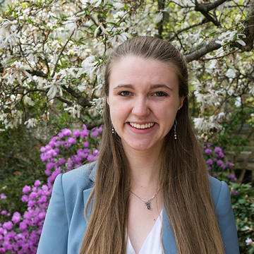 Sophie Everbach standing outside in front of trees.