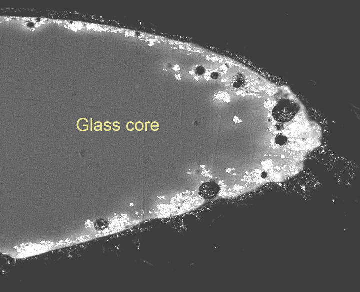 A microscopic view of a glass flower, with a label on the glass core.