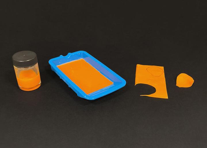 Pigmented resin, shown in the stages of liquid, drying, and cut to petal shapw.