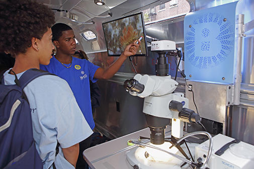 Children on the Biobus looking at a microscope