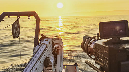 Image of camera recording ship at sunset
