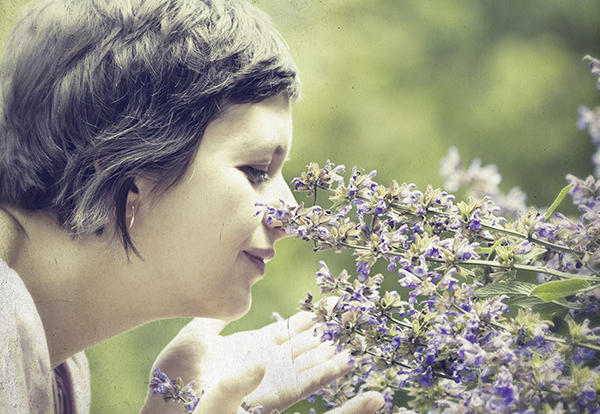 Woman smelling a plant.