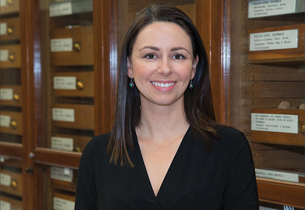 Woman, speaker Ashley S. Hammond, smiling in front on cabinets.