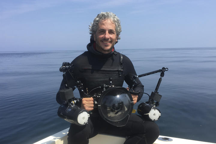 Keith Ellenbogen in a wetsuit surrounded by ocean.