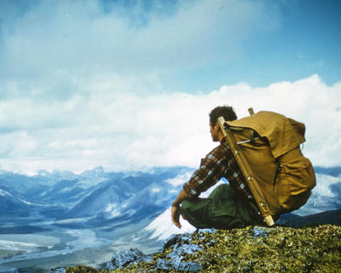 A backpacker takes in a vista of a mountain range.